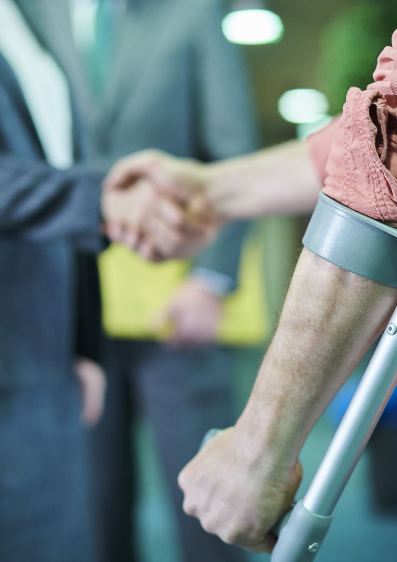 Man with crutch shaking a hand